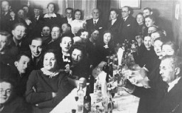 Family and friends are gathered for a Jewish wedding celebration in Kovno. Among those pictured are Jona and Gita Wisgardisky (standing at the back on the right).  
In the summer of 1941 soon after the German occupation of Lithuania, the Wisgardisky family was forced into the Kovno ghetto. During a roundup of children in the ghetto in 1942, Henia (Gita and Jona's daughter) was hidden in a secret room that her father built in a pantry in their apartment. Later she was smuggled out of the ghetto and placed with the Stankiewicz family. Jonas Stankiewicz had worked as the foreman in Jona Wisgardisky's chemical plant before the war, and had taken it over after the occupation.
After successfully securing a hiding place for their daughter, the Wisgardiskys fled from the ghetto. They found refuge on a potato farm, where they lived in a root cellar.
Photograph taken in Kovno, Lithuania, ca. 1938.