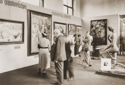 Un grupo de visitantes observan una exposición de arte degenerado (Entartete Kunst) en el Munich Hofgarten. Entre otras, es posible ver obras de Lovis Corinth y Franz Marc.