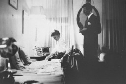 Jan Karski (berdiri), kurir bawah tanah untuk pemerintah Polandia dalam pengasingan yang menginformasikan kepada barat pada musim gugur tahun 1942 mengenai kejahatan Nazi terhadap kaum Yahudi yang terjadi di Polandia. Difoto di kantornya di Washington, DC, Amerika Serikat, 1944.