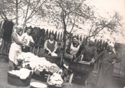 Four of Norman's sisters, the maid, and Norman's mother, Esther, do laundry in the yard of their home. Kolbuszowa, Poland, 1934.