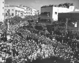 Crowds gathered in the streets of Tel Aviv celebrate the anniversary of the establishment of Israel with an independence day parade. Tel Aviv, Israel, May 1949.