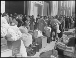 American residents of Japanese ancestry wait with their luggage for transportation during relocation, San Francisco, California, April 6, 1942.  