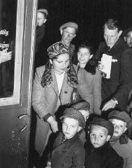 A welfare officer of the United Nations Relief and Rehabilitation Administration (UNRRA) assists Polish Jewish orphans en route to France and Belgium. Prague, Czechoslovakia, probably 1946.