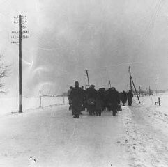 Un transporte de prisioneros judíos avanza por la nieve, desde la estación de trenes de Bauschovitz hasta Theresienstadt. Checoslovaquia, 1942.