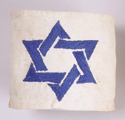 Un brazal blanco con la estrella de David bordada en hilo azul, usada por Dina Offman desde 1939 hasta 1941 mientras estaba en el ghetto de Stopnica, Polonia.
