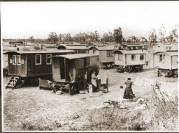 Mujeres romaníes (gitanas) hierven ropa y la cuelgan a secar en el medio del campamento en Marzahn. Alemania, junio de 1936.