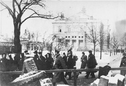 Deportation of Jews from Plzen (Pilsen) to Theresienstadt. The building in the background is the town theater. Czechoslovakia, 1942.