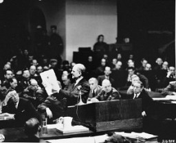En la sala del Tribunal Militar Internacional, un fiscal litigante procesal, el coronel Robert G. Storey, presenta pruebas de las intenciones nazis de iniciar una guerra de agresión.