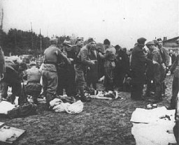 Des gardiens oustachi (fascistes croates) fouillent des prisonniers et leur prennent leurs biens à leur arrivée au camp de concentration de Jasenovac. Yougoslavie, entre 1941 et 1945.