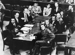 US Brigadier General Telford Taylor (front right), chief of counsel, sits at the prosecution table with his staff during the reading of charges against the defendants in the RuSHA Trial. October 10, 1947.