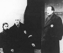 In a scene from a Nazi propaganda film, Dr. Paul Eppstein (right), Council of Elders chairman, addresses Dutch Jews. Theresienstadt ghetto, Czechoslovakia, August 1944.