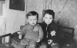 Kovno gettosunda aile fotoğrafı için yan yana oturtulmuş iki küçük kardeş. Bir ay sonra Majdanek kampına sevk edildiler. Şubat 1944, Kovno, Litvanya.