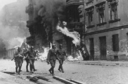 Niemieccy żołnierze palący po kolei budynki mieszkalne podczas powstania w getcie warszawskim. Polska, 19 kwietnia-16 maja 1943 r.