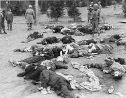 US soldiers of the 4th Armored Division survey the dead at Ohrdruf, a subcamp of the Buchenwald concentration camp. Germany, April 1945.