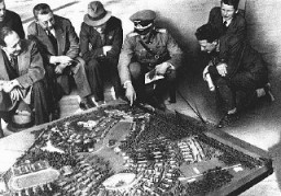 Os nazistas investiram enormes quantias na preparação para os Jogos Olímpicos. Nesta foto, oficiais alemães exibem a maquete da Vila Olímpica para demonstrar o quão grande seria o resultado final. Berlim, Alemanha. Julho 1936.