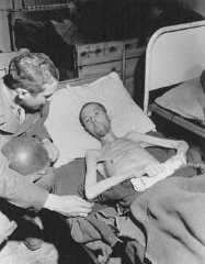 Вскоре после освобождения: солдат армии США расспрашивает истощенного советского военнопленного в лагере принудительного труда. Дортмунд, Германия, 30 апреля 1945 года.