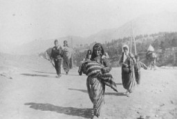 A small group of Armenian deportees walking through the Taurus Mountain region, carrying bundles. A woman in the foreground carries a child. Ottoman Empire, ca. November 1915. Photograph taken by Armin T. Wegner. Wegner served as a nurse with the German Sanitary Corps. In 1915 and 1916, Wegner traveled throughout the Ottoman Empire and documented atrocities carried out against the Armenians. [Courtesy of Sybil Stevens (daughter of Armin T. Wegner). Wegner Collection, Deutsches Literaturarchiv, Marbach & United States Holocaust Memorial Museum.]