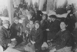 Jews from Macedonia who were rounded up and assembled in the Tobacco Monopoly transit camp before deportation to the Treblinka killing center. Skopje, Yugoslavia, March 1943.
The Jews of Bulgarian-occupied Thrace and Macedonia were deported in March 1943. On March 11, 1943, over 7,000 Macedonian Jews from Skopje, Bitola, and Stip were rounded up and assembled at the Tobacco Monopoly in Skopje, whose several buildings had been hastily converted into a transit camp. The Macedonian Jews were kept there between eleven and eighteen days, before being deported by train in three transports between March 22 and 29, to Treblinka.