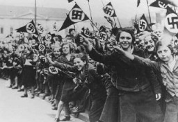 Membres de la Ligue des jeunes-filles allemandes (Bund Deutscher Mädel) agitant des drapeaux nazis en soutien de l’annexion de l’Autriche par les Allemands (l’Anschluss). Vienne, Autriche, mars 1938.