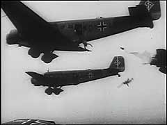 Germany launched its western offensive on May 10, 1940. German paratroopers landed in the Netherlands on the first day of the German attack on that country. They seized key bridges and fortifications, compromising Dutch defensive positions. This footage shows the German air force (Luftwaffe) dropping paratroopers near Rotterdam. Within days, the Netherlands was defeated. The country surrendered to Germany on May 14. The Dutch government and Queen Wilhelmina fled to exile in Great Britain.