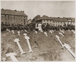 Under orders from officers of the US 8th Infantry Division, German civilians from Schwerin attend funeral services for 80 prisoners killed at the Wöbbelin concentration camp. The townspeople were ordered to bury the prisoners' corpses in the town square. Germany, May 8, 1945.