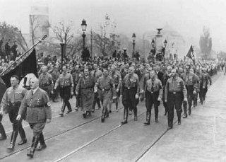 Adolf Hitler, Julius Streicher (foreground, right), and Hermann Goering (left of Hitler) retrace the steps of the 1923 Beer Hall ...