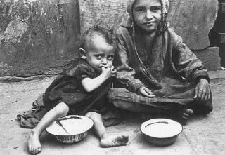 Enfants mangeant dans les rues du ghetto de Varsovie.