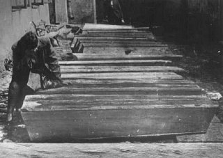 Egy nő gyászol a kielcei pogrom során meggyilkolt zsidók koporsója mellett.