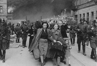 German soldiers lead Jews captured during the Warsaw ghetto uprising to the assembly point for deportation.