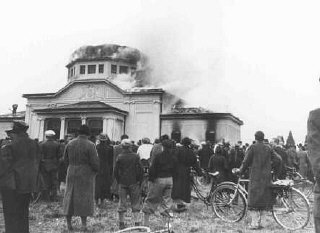 Kristallnacht (“Kırık Camlar Gecesi”) sırasında yerel halk, Graz Yahudi mezarlığındaki merasim salonunun yanışını izliyor.