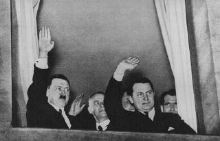 Adolf Hitler, Wilhelm Frick, et Hermann Goering font signe lors d'un défilé aux flambeaux en l’honneur de la nomination d’Hitler ...