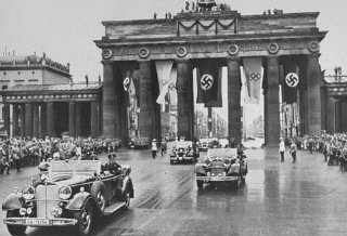 Adolf Hitler passes through the Brandenburg Gate on his way to the opening ceremonies of the Olympic Games