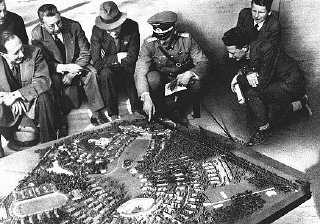 صرف النازيون الكثير من المال لاعداد الألعاب الأولمبية. ونرى هنا ضباط ألمان يعرضون نموذجا من قرية الألعاب الأولمبية.